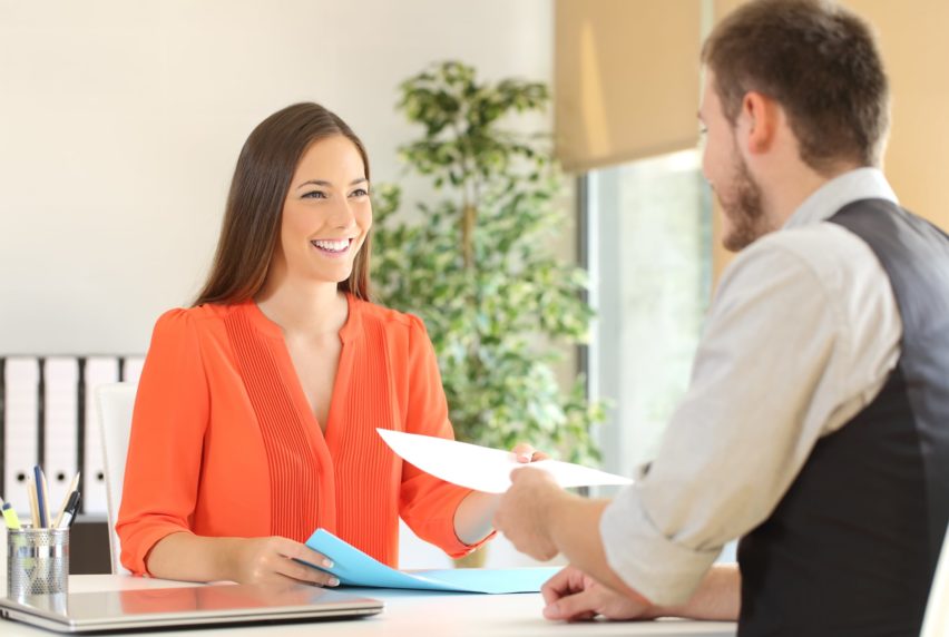 Woman giving a resume to the interviewer in a job interview
